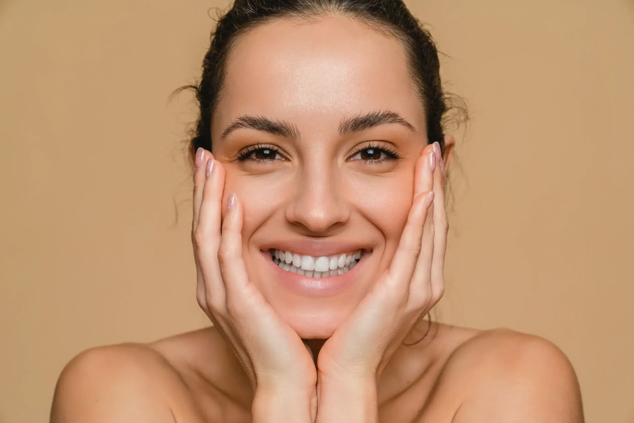 Woman studying indented acne scars along her cheek in soft side lighting in Lake Havasu City