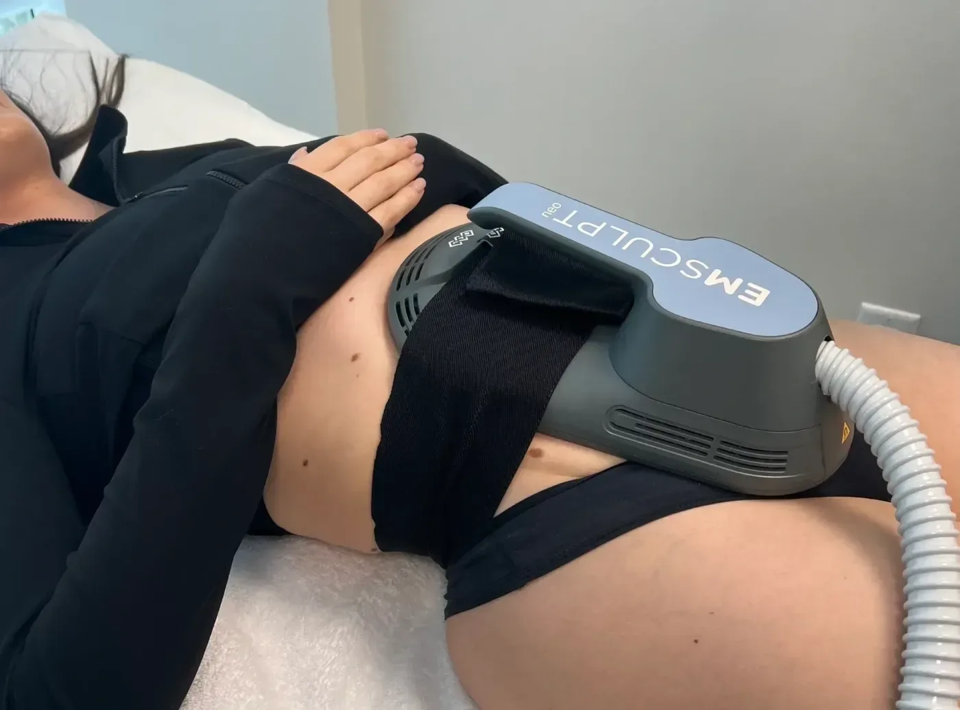 Emsculpt Neo applicator belted over the abdomen during a session at Desert Oasis Wellness and Med Spa in Lake Havasu City