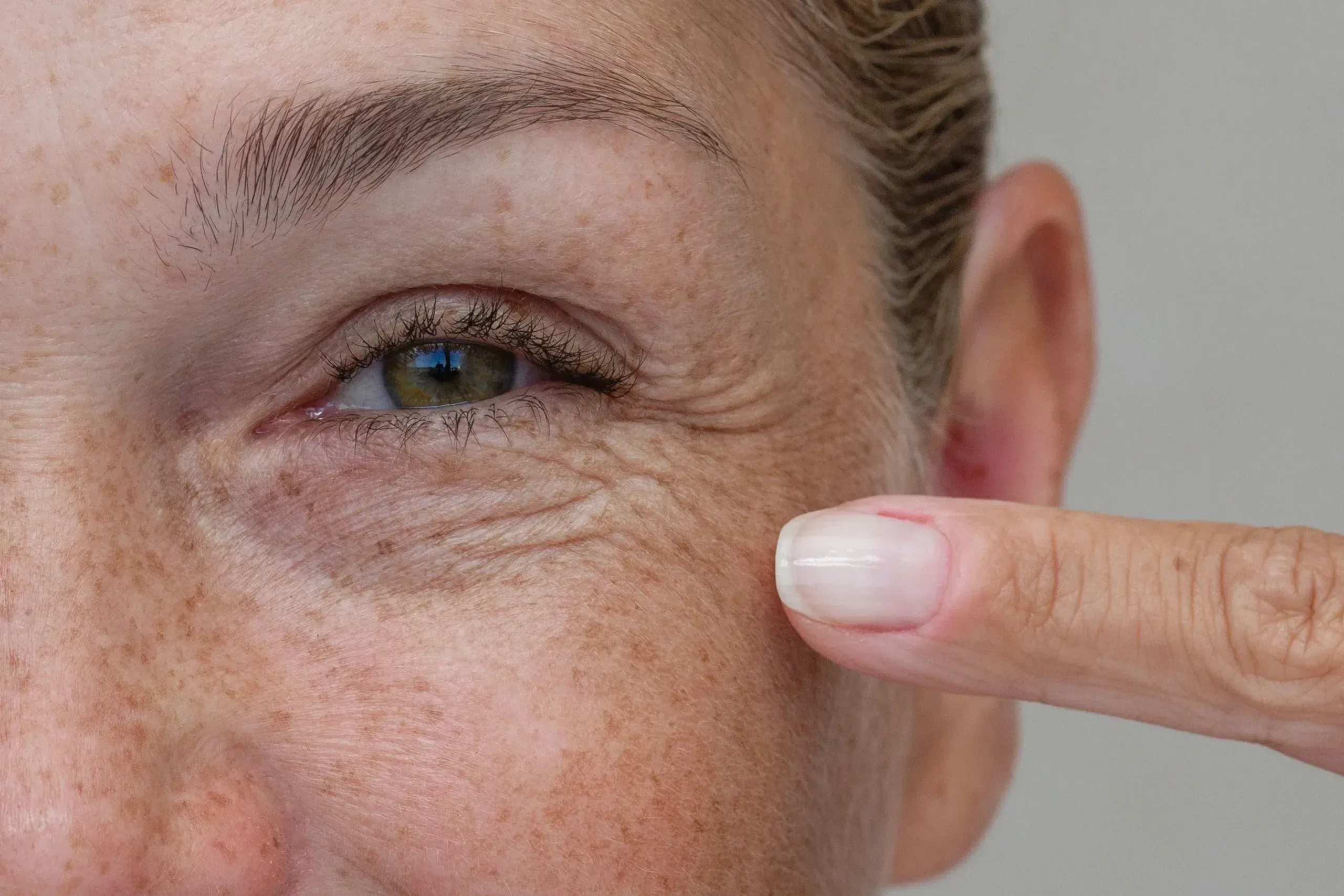 Woman in her fifties studying the fine lines and wrinkles around her eyes in Lake Havasu City